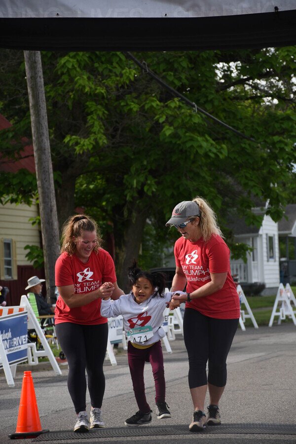 A Captain crosses the finish line with two Angels at Wabash Run the River.