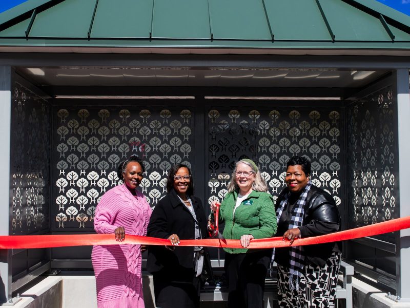 (From left) Councilwoman Rohli Booker, Mayor Sharon Tucker, Harvester Neighborhood Association President Margaret Machlan, and SE Area Partnership President Denita Washington pose at the bus shelter ribbon cutting ceremony.