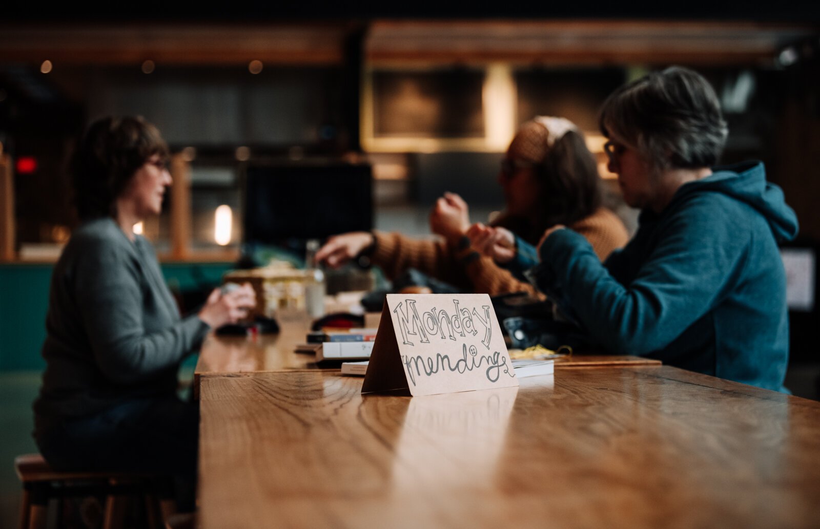 From left: Jennie Renner, Megan Burton, and Mia Morris work on mending projects.