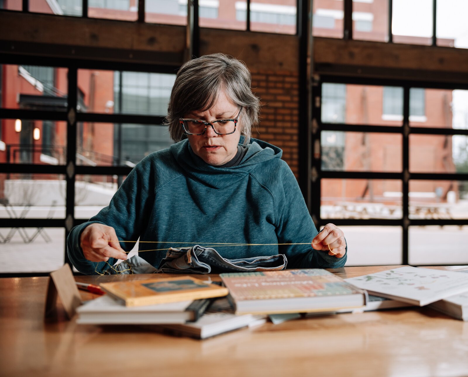 Mia Morris works on embroidering a pair of jeans.