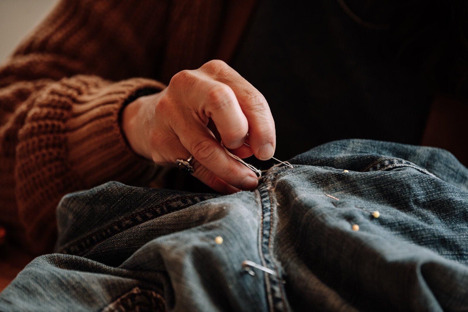 Megan Burton works on helping Mia Morris (not pictured) embroider a pair of jeans.