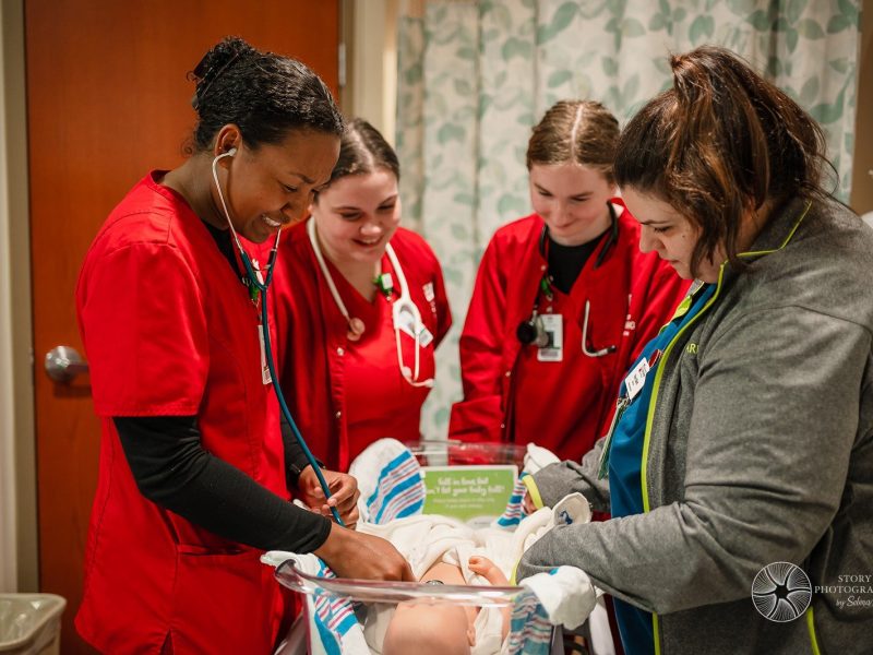 With the help of Parkview Nurse and Indiana University Fort Wayne Instructor Roni Elliott, an IUFW student simulate taking vitals on an infant.