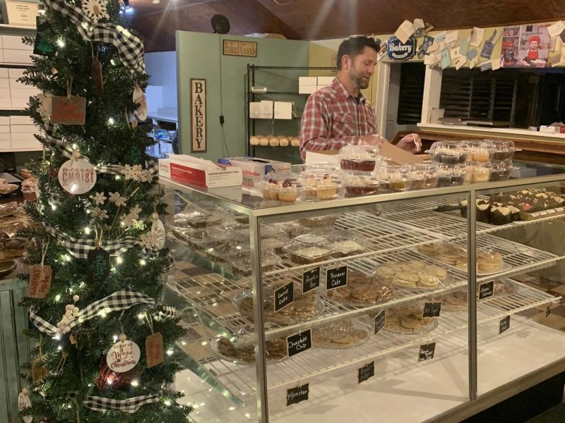 David Jimenez, owner of Nordmann's Nook, pulls a baked good from the display case for a customer.