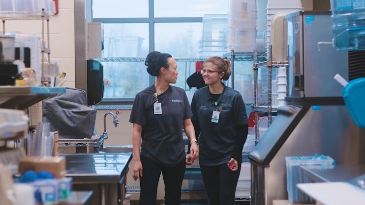 Maddy Ball works with a co-worker in nutrition services.