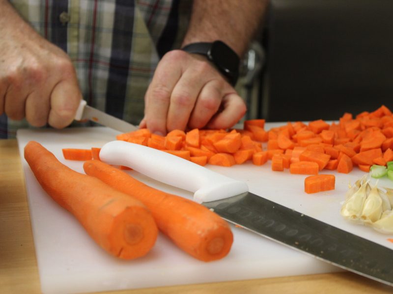 David Rigby, Ruth-Anne’s grandfather, helps shop up carrots as part of the Our HEALing Kitchen class at Shepherd’s House.