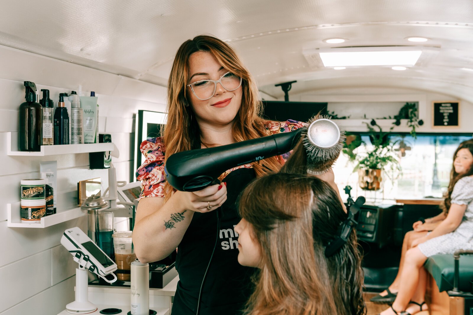 Owner Beth Morken works on giving Avyn Oliver, 10, a kid's cut, blow dry and style on the 260HairBus.