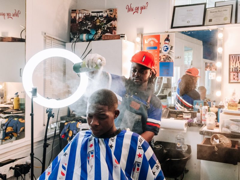 Barber Benson Harvey, owner of Smooth Kutz, works on giving Roderick Williams a bald fade.
