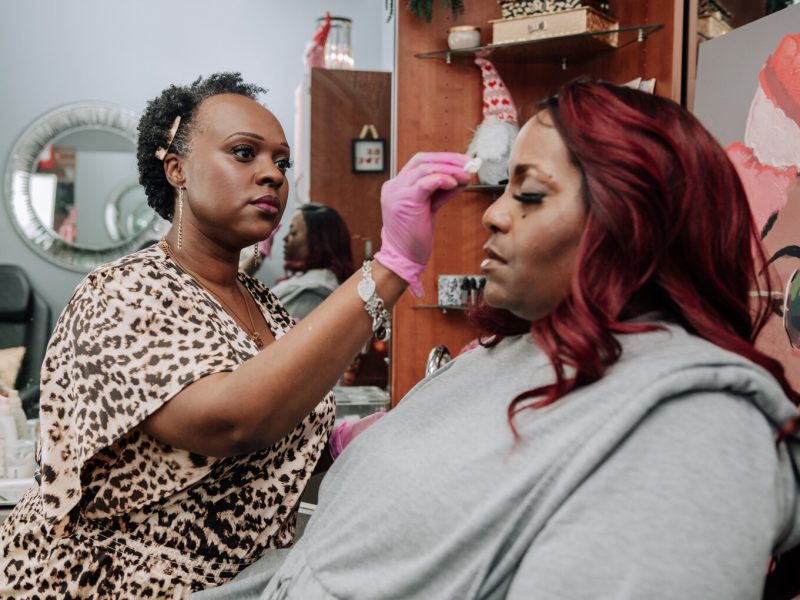 Rohli Booker with Aza Image Beauty & Brow Studio does a brow wax and fill eyebrow service for Toya T. in her studio.