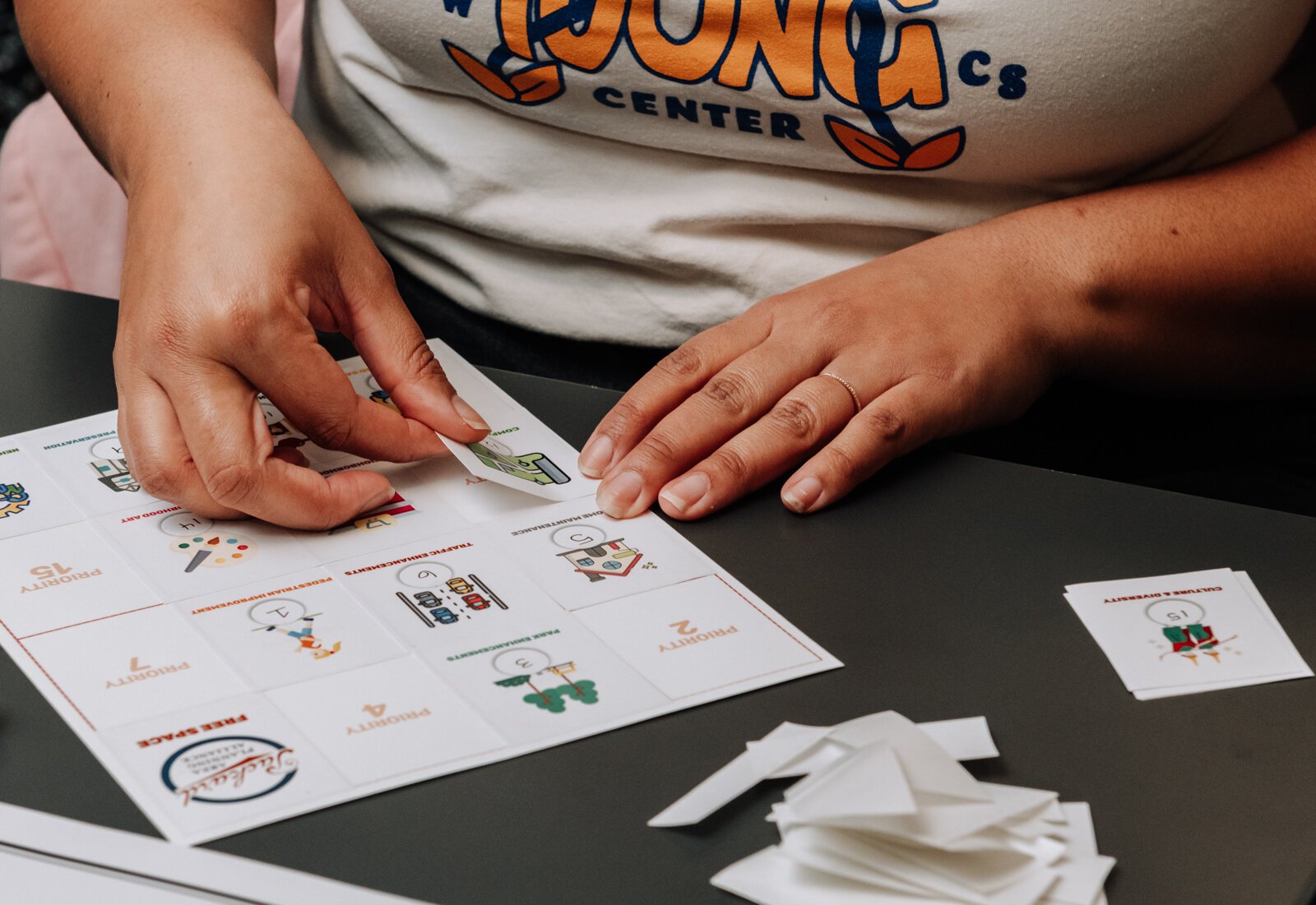Residents fill out their boards for the game LoterÃa during the Packard Area Planning Alliance retreat at the Boys and Girls Club on Fairfield Ave.