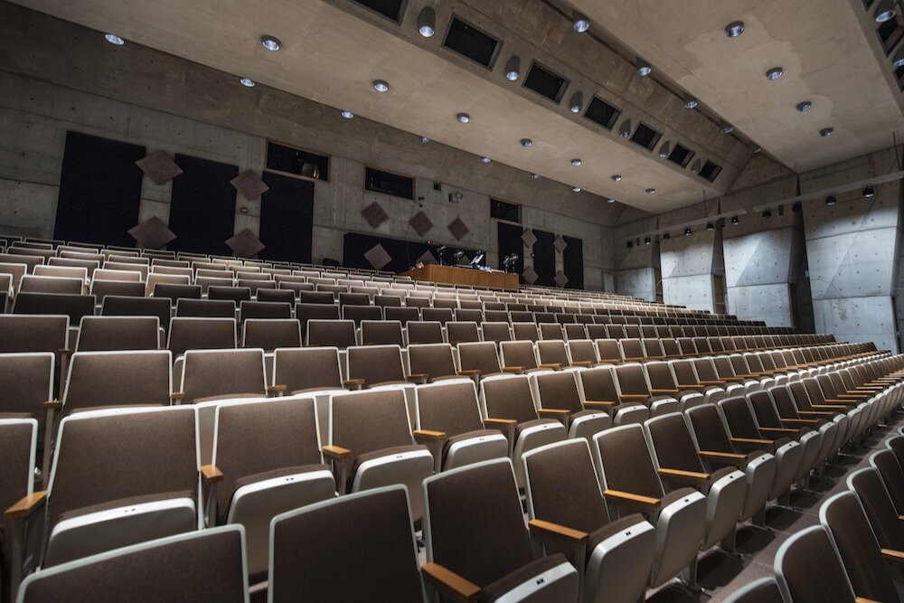 Instead of ornamental designs, the auditorium's walls are sleek, functional concrete.