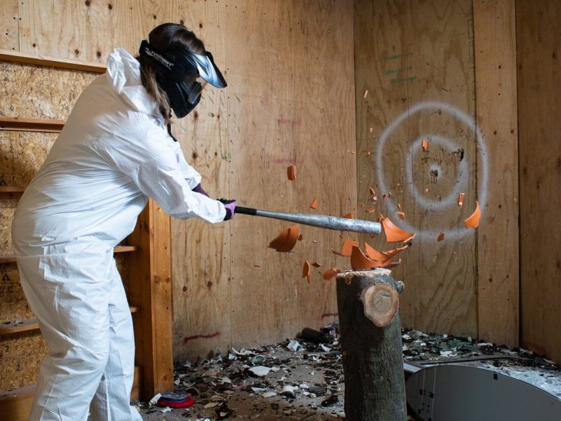 Abby Greutman hits a pot with a baseball bat at All the Rage.