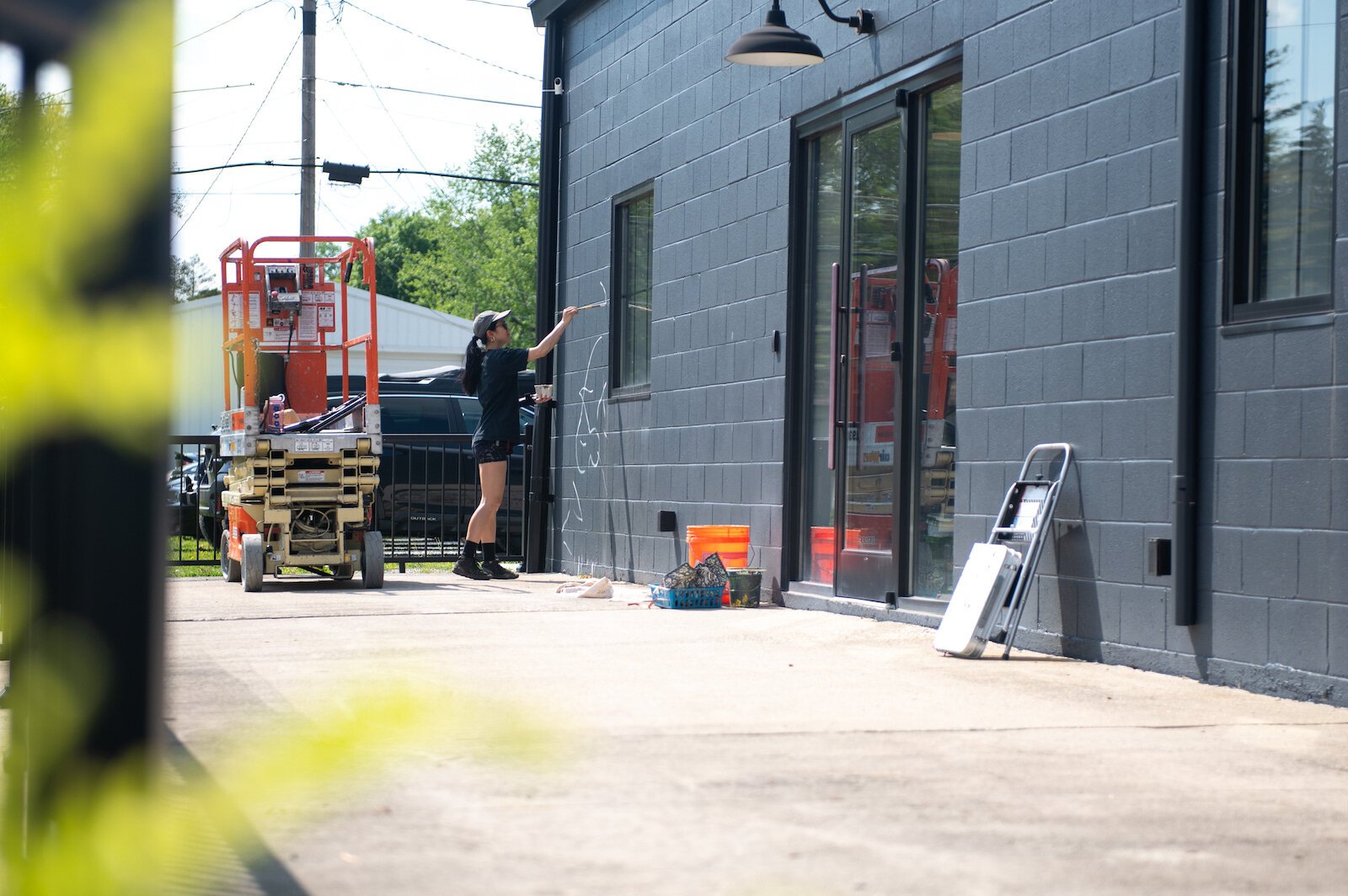 Detroit-based artist Louise 'Ouizi' Jones paints a mural in downtown Roanoke inspired by common Indiana flowers, including peonies and black-eyed Susans.