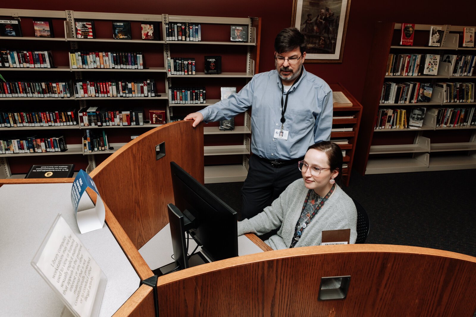 Branch Manager Christopher R. Wiljer helps Librarian Kristina Lay with the computer at the Allen County Public Library's Monroeville branch.