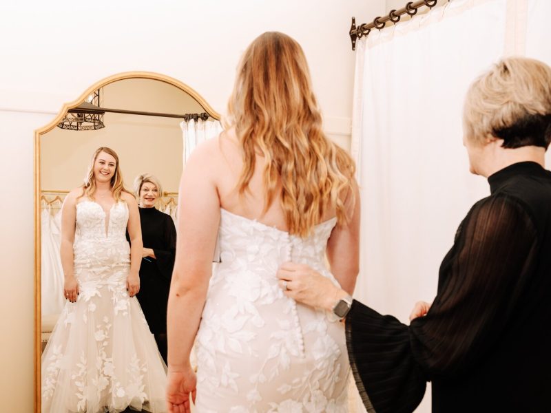 Lisa Downs, owner of Ellen's Bridal & Dress Boutique, helps customer Bailey Lundmark with a dress she is trying on