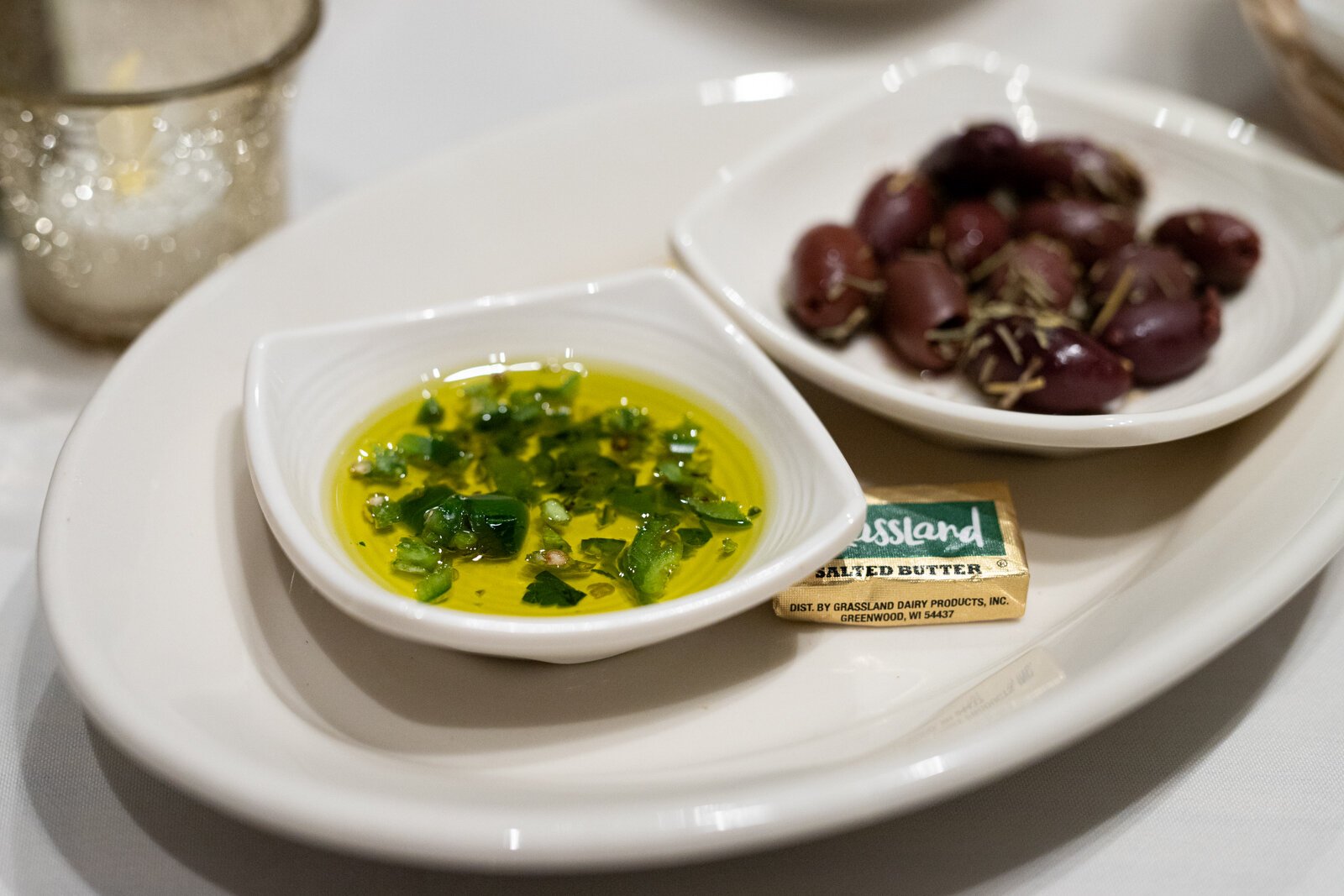 A small saucer of marinated kalamata olives and rosemary accompanies the bread and oil for a snack that’s rich and gets you salivating for your meal to come.