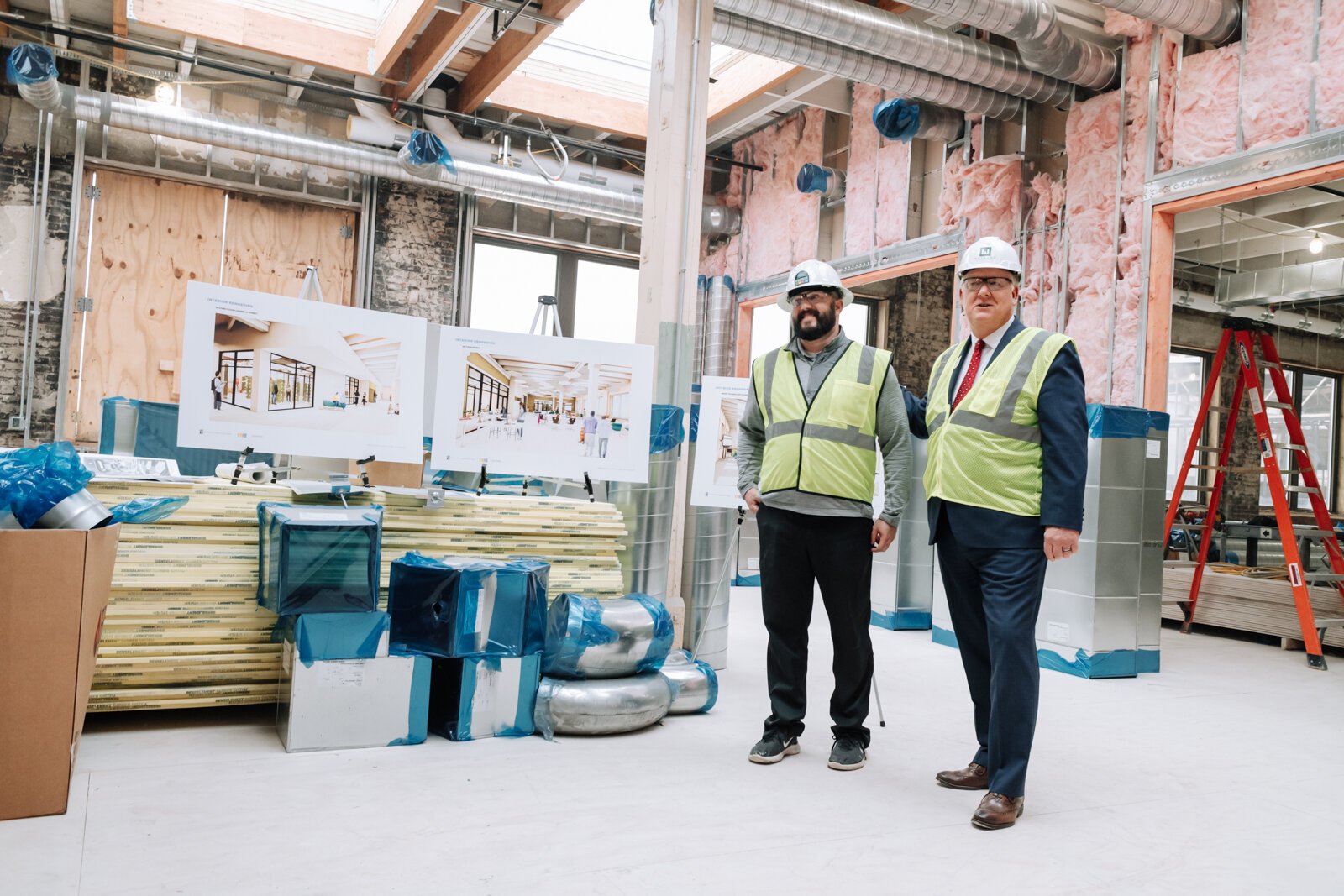 Riley Johnson, left, Director of the Amp Lab at Fort Wayne Community Schools, speaks with members of the media inside the Amp Lab's future space in Building 31 of Electric Works. (December 2021)