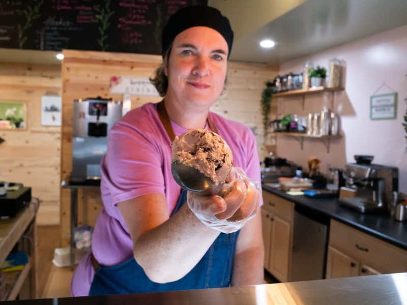 Julie Hurd, owner of Moo-Over Ice Cream, scoops her vegan, plant-based "Cookies in Pink" ice cream at her shop in Columbia City.