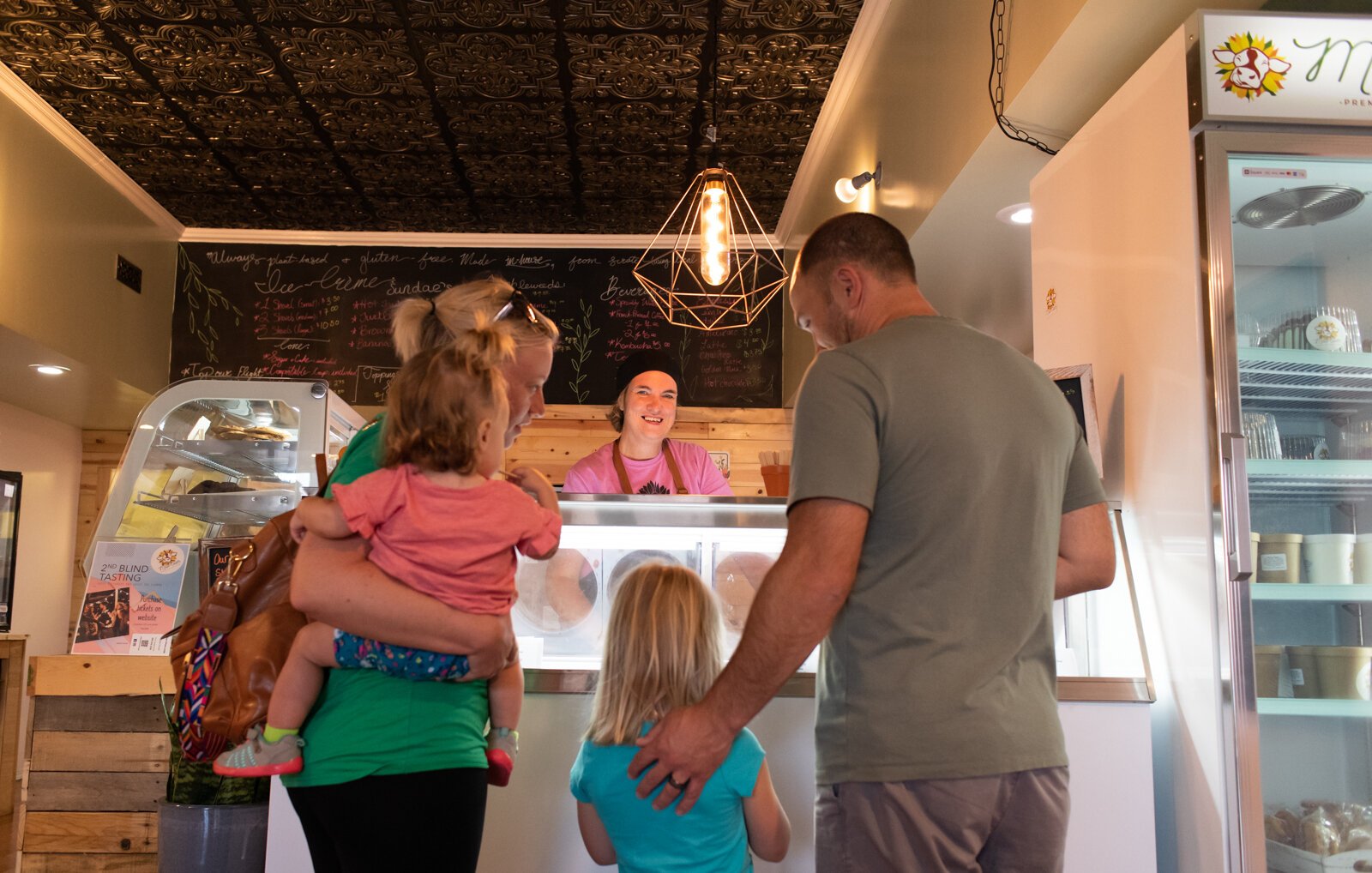 Julie Hurd, owner at Moo-Over Ice Cream, 207 W. Van Buren St. in Columbia City, helps the Girardot family select a flavor of ice cream.
