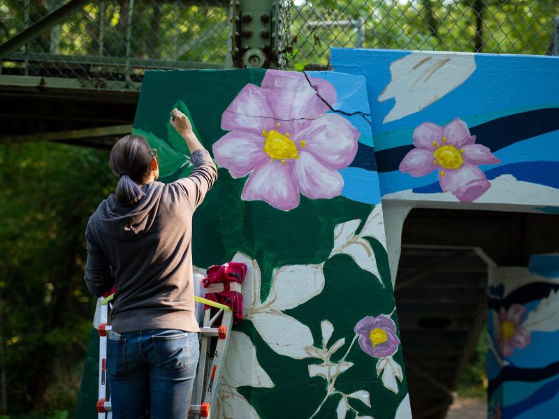Suzanne Rhee works on her mural in Foster Park.