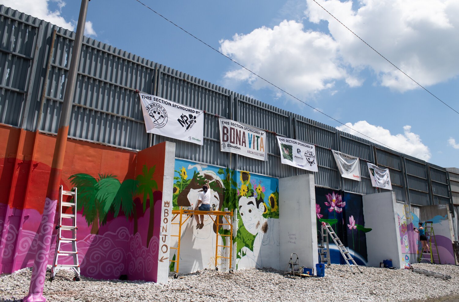 Artists work on the murals during "Elevation. A Summit City Mural Showcase" on the 2400 block of Central Dr. in Fort Wayne.