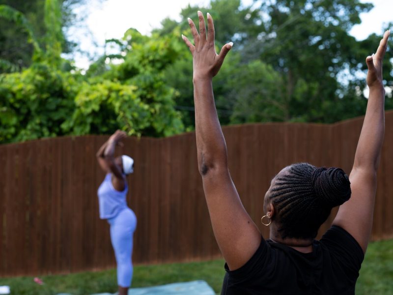 Diane Rogers, left, a longtime resident and current President of the Oxford Community Association, leads a yoga class in her backyard for her neighborhood and community drop-ins.