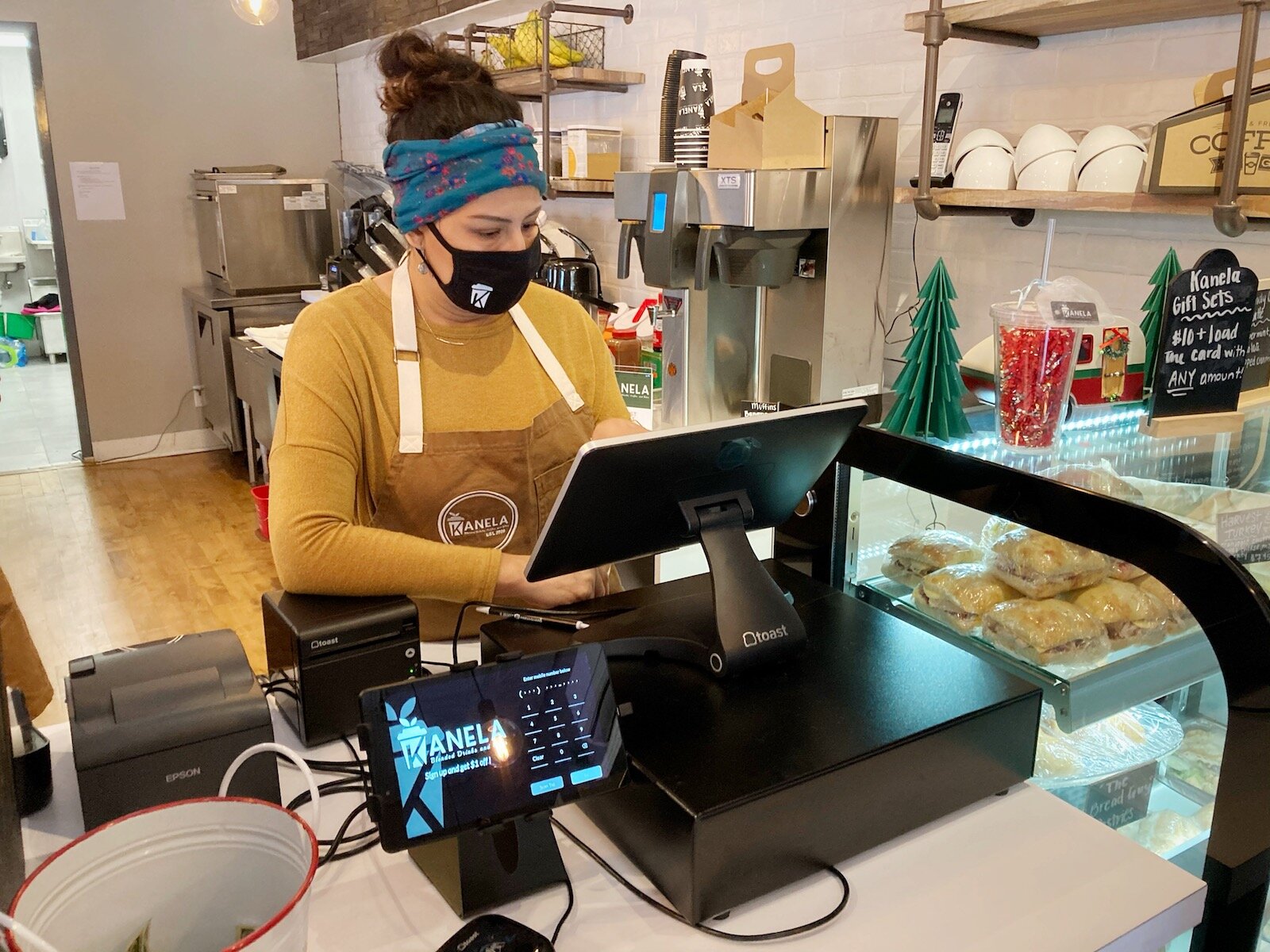 Flora Barron works the cash register at her new smoothie, juice, and coffee shop, Kanela.