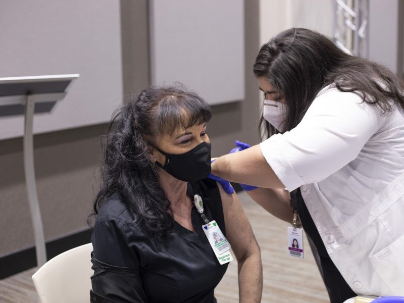 Marsha Franklin, a respiratory therapist at Parkview Regional Medical Center, receives her first dose of the COVID-19 vaccine on Dec. 14, 2020, from Maryam Noureldin, ambulatory pharmacist.