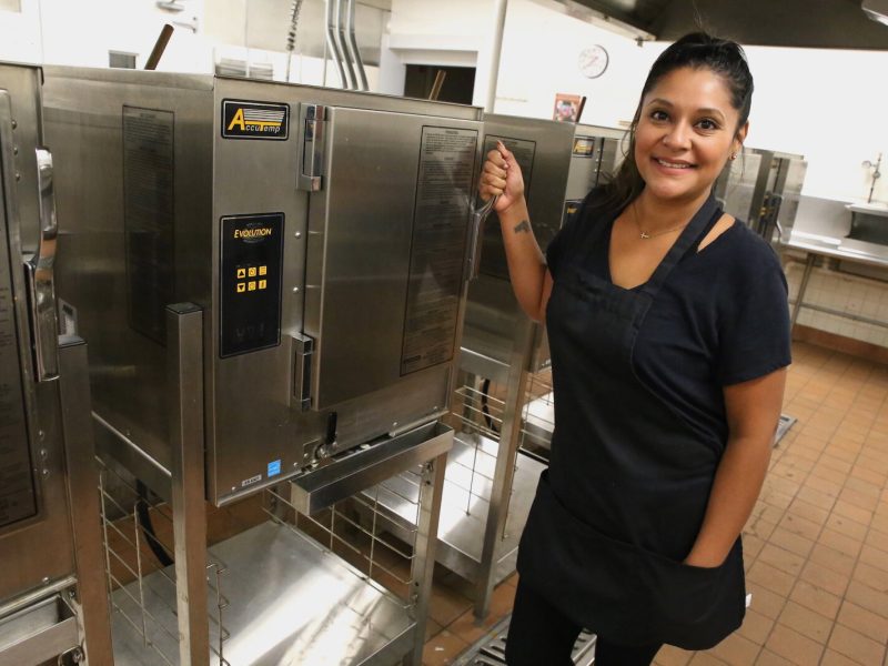 Ruiz poses with her favorite kitchen tool: The industrial steamers at the Community Harvest Food Bank's shared kitchen.