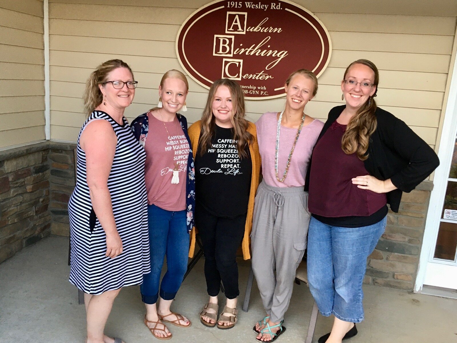 Shanna Bradley, second from left, and Laura Kiefer, second from right, pose together at a meeting of the Journey Birth and Wellness team and the Auburn Birthing Center midwives.