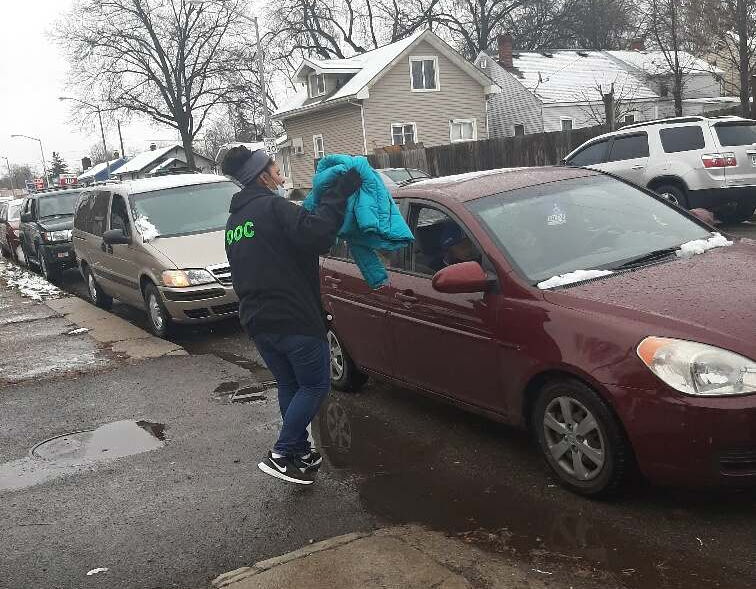 Volunteers deliver coats to cars at the November curbside giveaway.