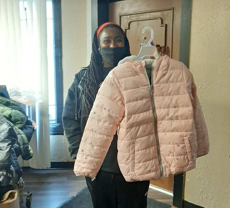 Sheena Greene, Founder of Black Women of Excellence in Fort Wayne, helps distribute coats the November curbside giveaway.