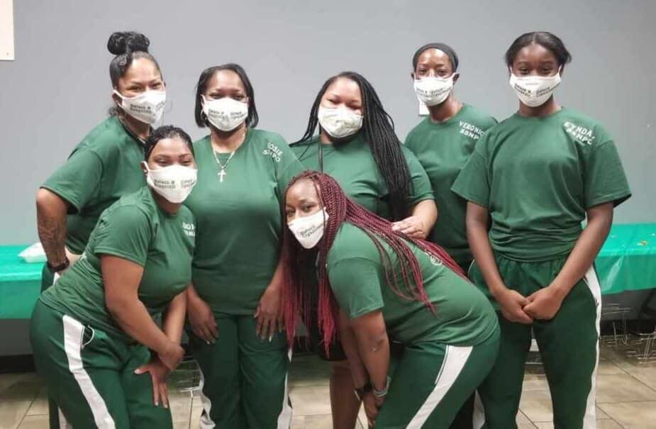 Members of the Sistarz & Sistarz Nonprofit Organization don masks to serve food in Southeast Fort Wayne.