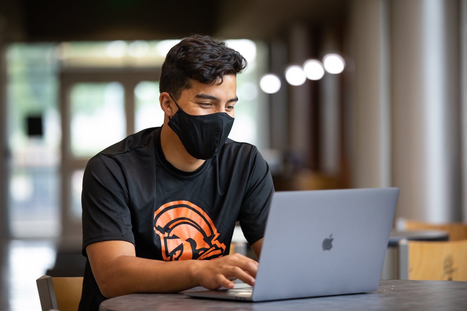 A student at Indiana Tech works while wearing a mask.
