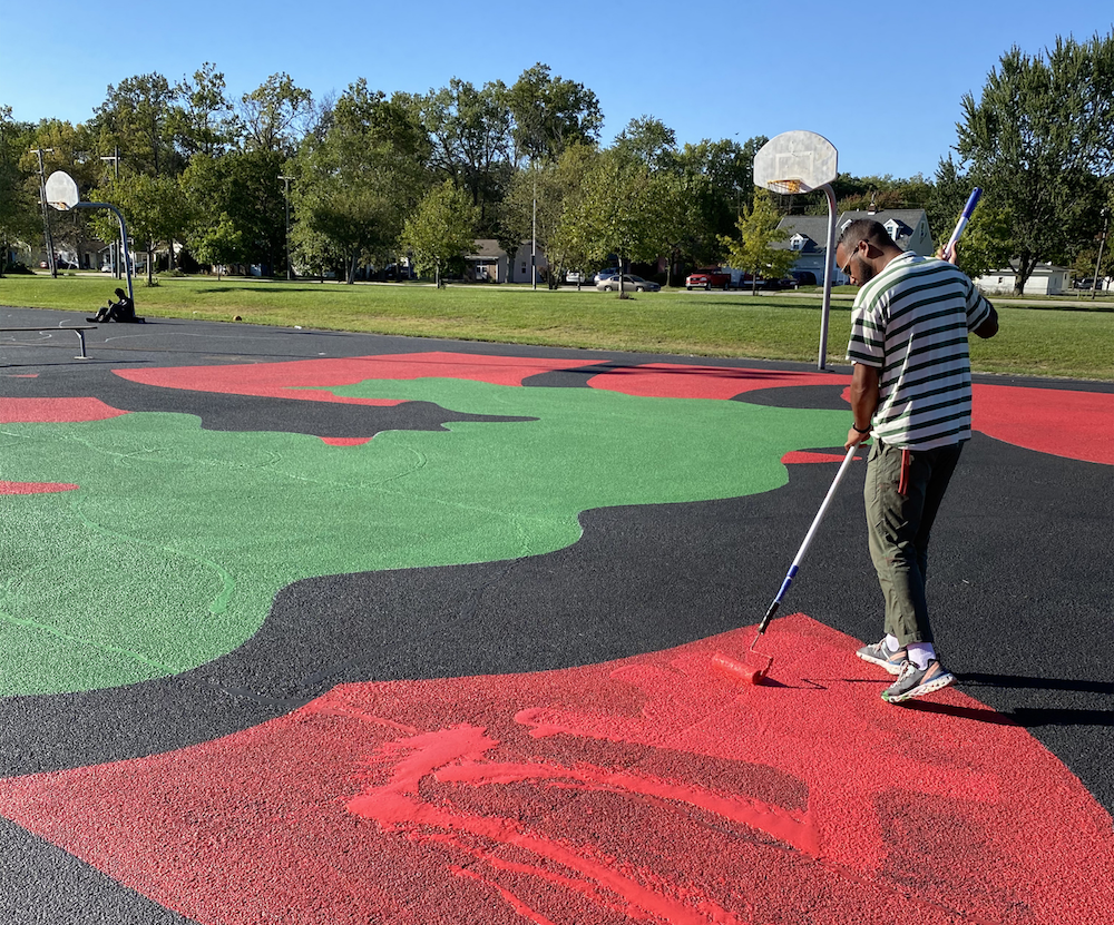 Portee, right, paints one of four basketball courts at McMillen Park.