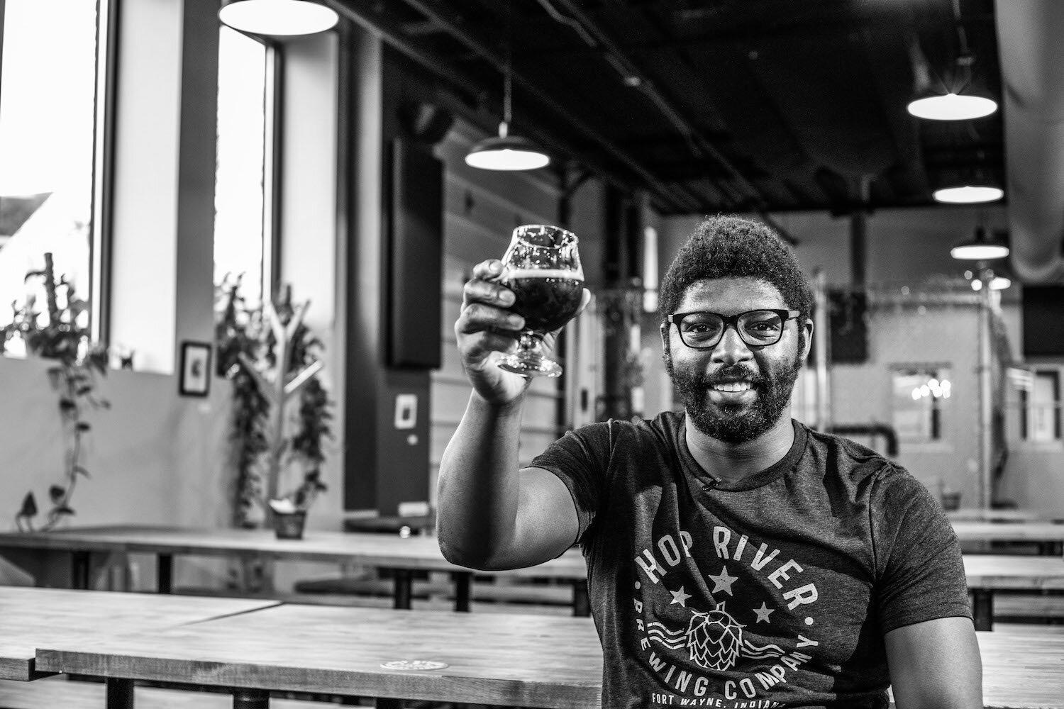 Hop River Vice President and Co-Founder Paris McFarthing raises a glass to craft beer and community in Fort Wayne.