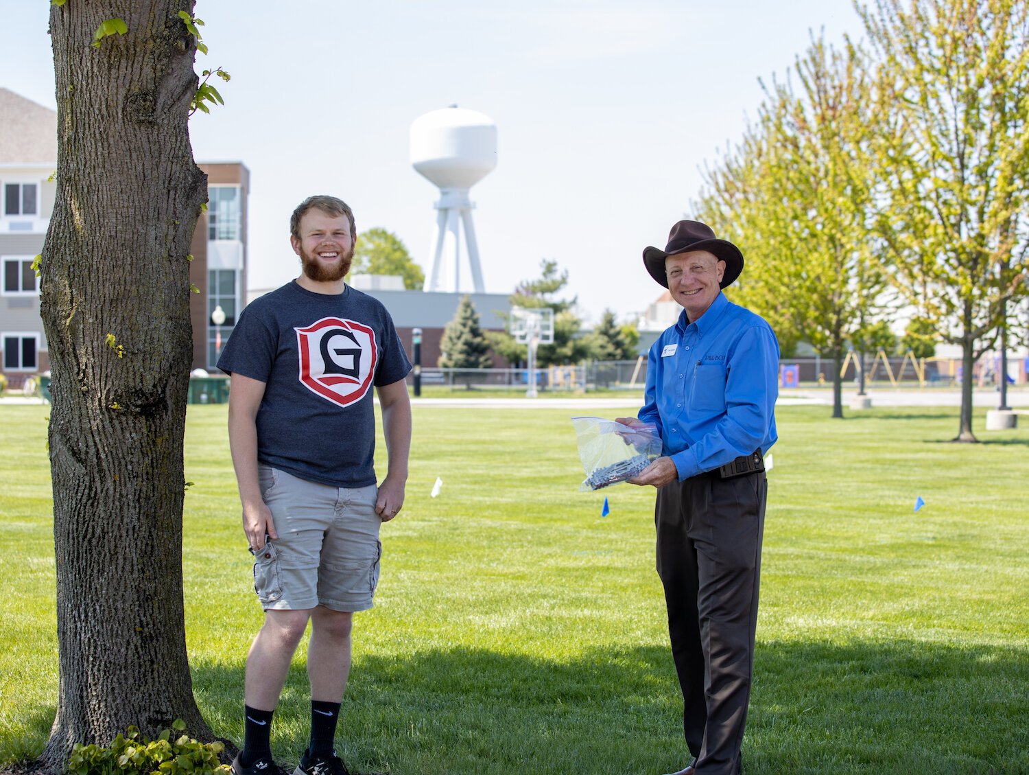 Abbott Joy, left, delivers ear guards to Paul Derenzo of Pill Box Pharmacy.