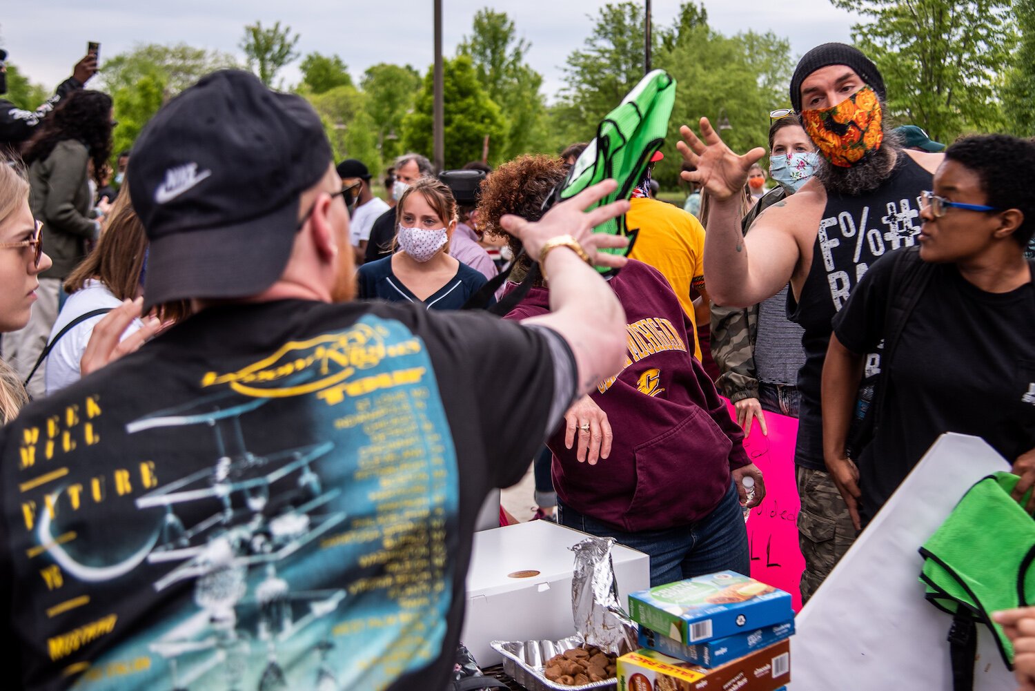 Organizer Steven Green throws a vest to John Campbell, who volunteered as a peace moderator for an event to protest the death of George Floyd and social injustice June 1 outside the Bovee University Center in Mount Pleasant, MI.