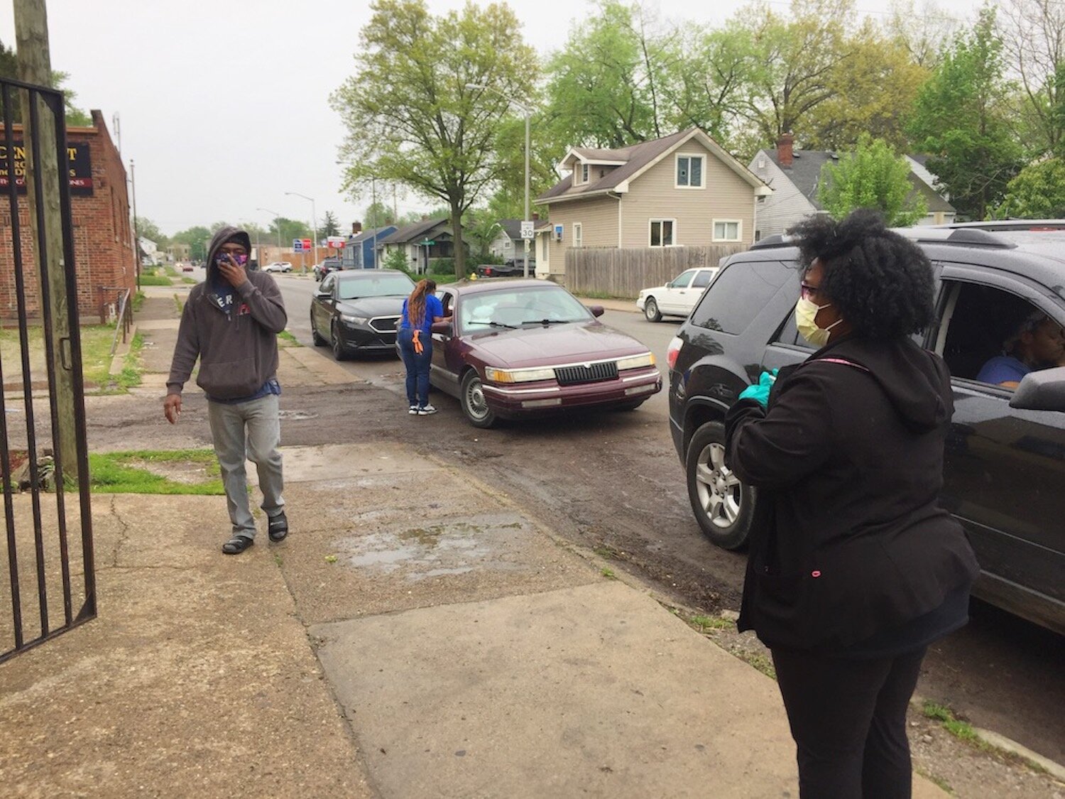 Volunteers with the Curbside BBQ carry meals to vehicles.