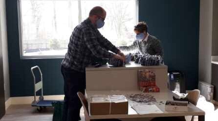 Hayes, right, helps volunteer PJ Thuringer pack boxes.