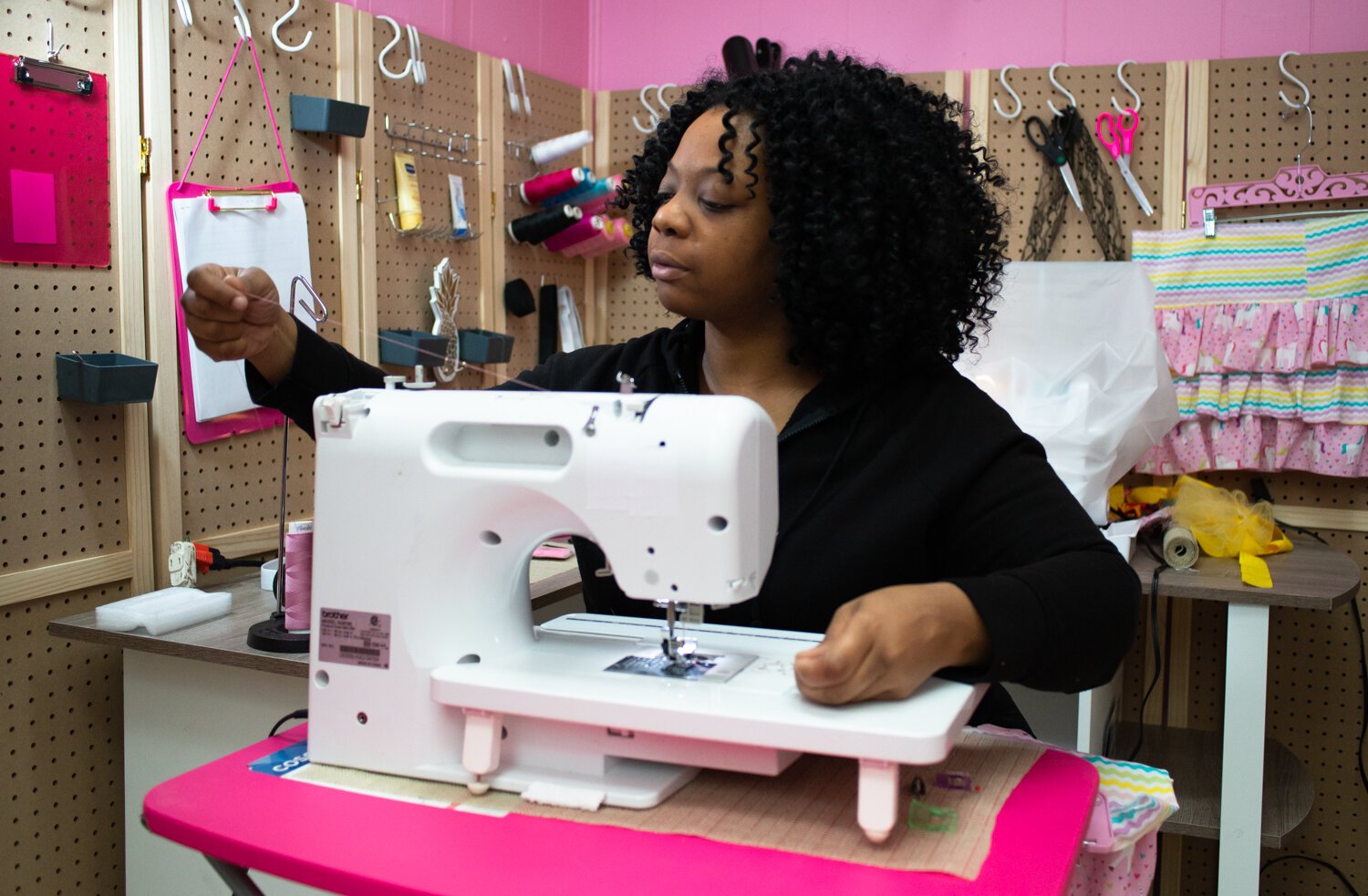 Pinky spools the thread on her sewing machine.