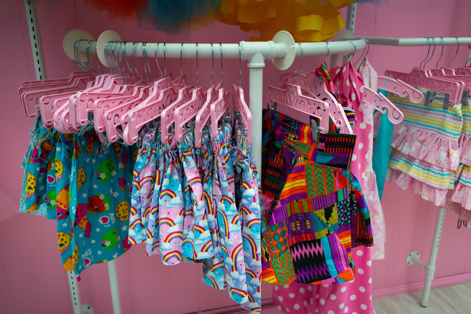 Colorful garments adorn the walls at Sew Pinky's shop.