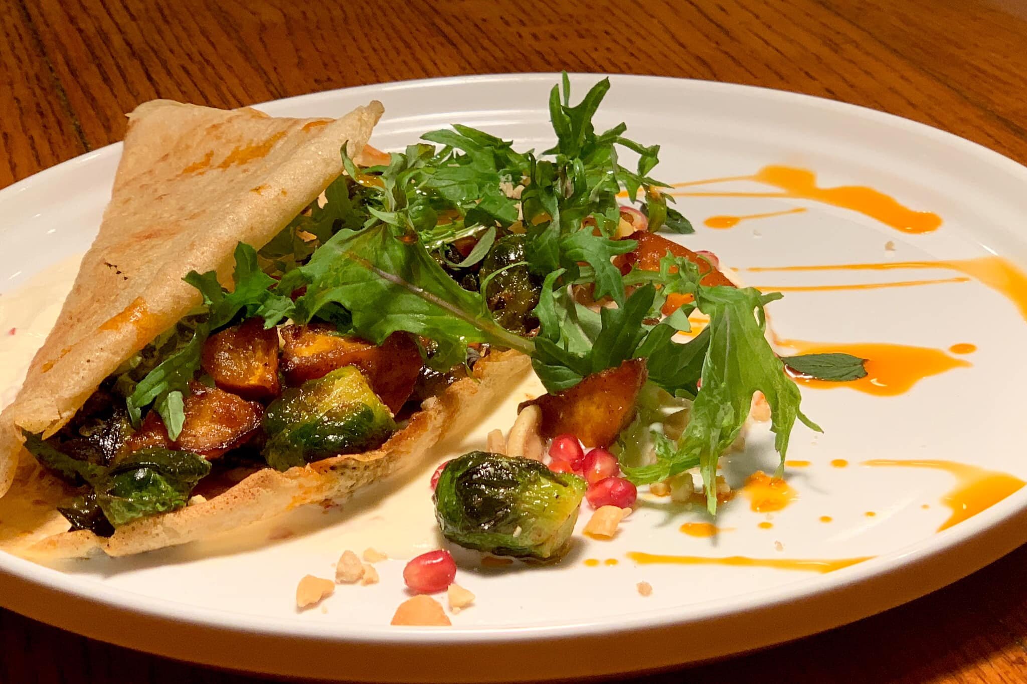 Joseph Decuis serves roasted winter veggies: sweet potato, Brussels sprouts, pomegranate, creme fraiche, and cashew.