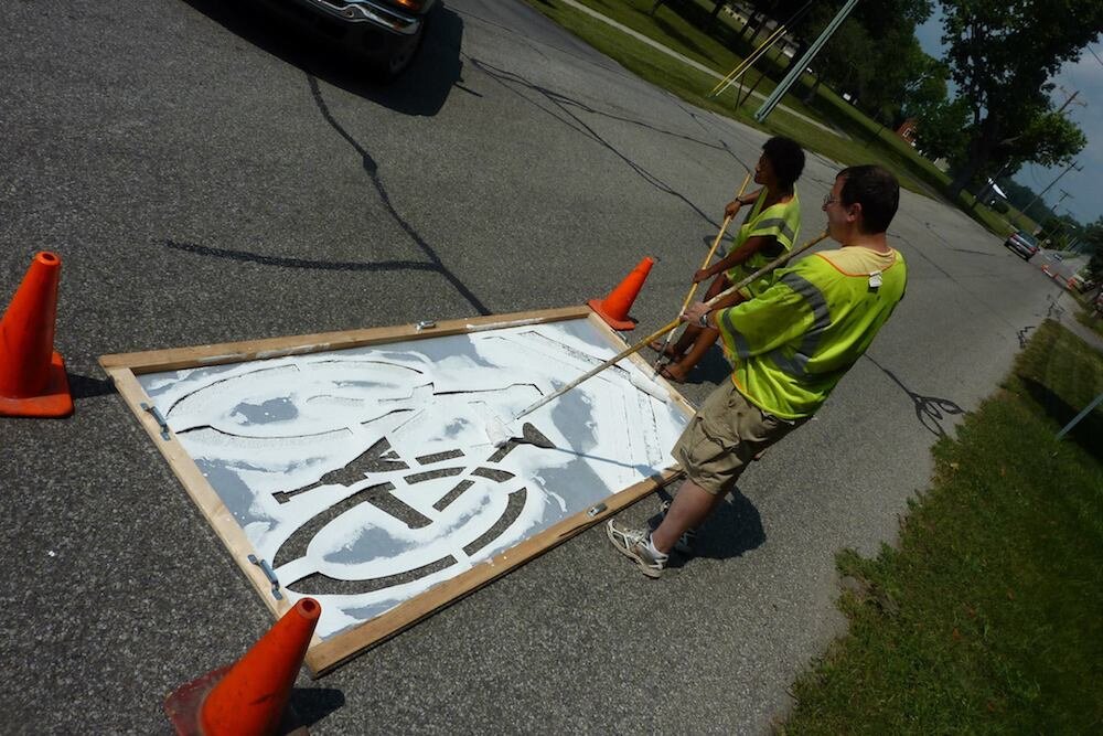 Robinson helps paint a bike lane as part of Manchester Main Street.