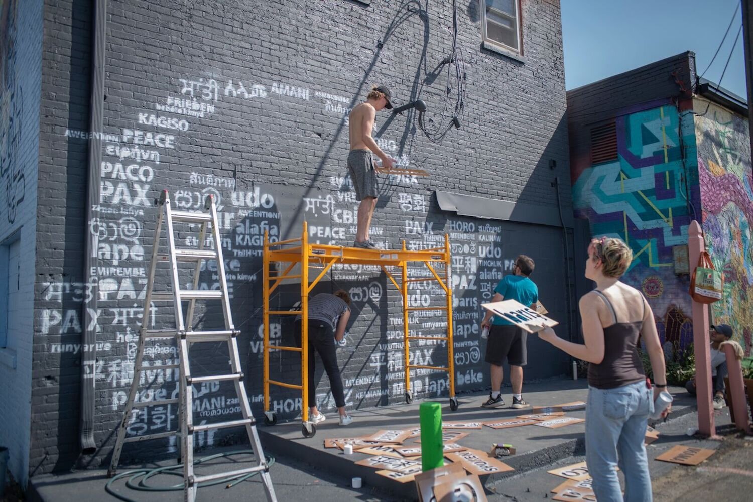 Wunderkammer volunteers paint the mural portion of the Pax Fortlandia Activation.