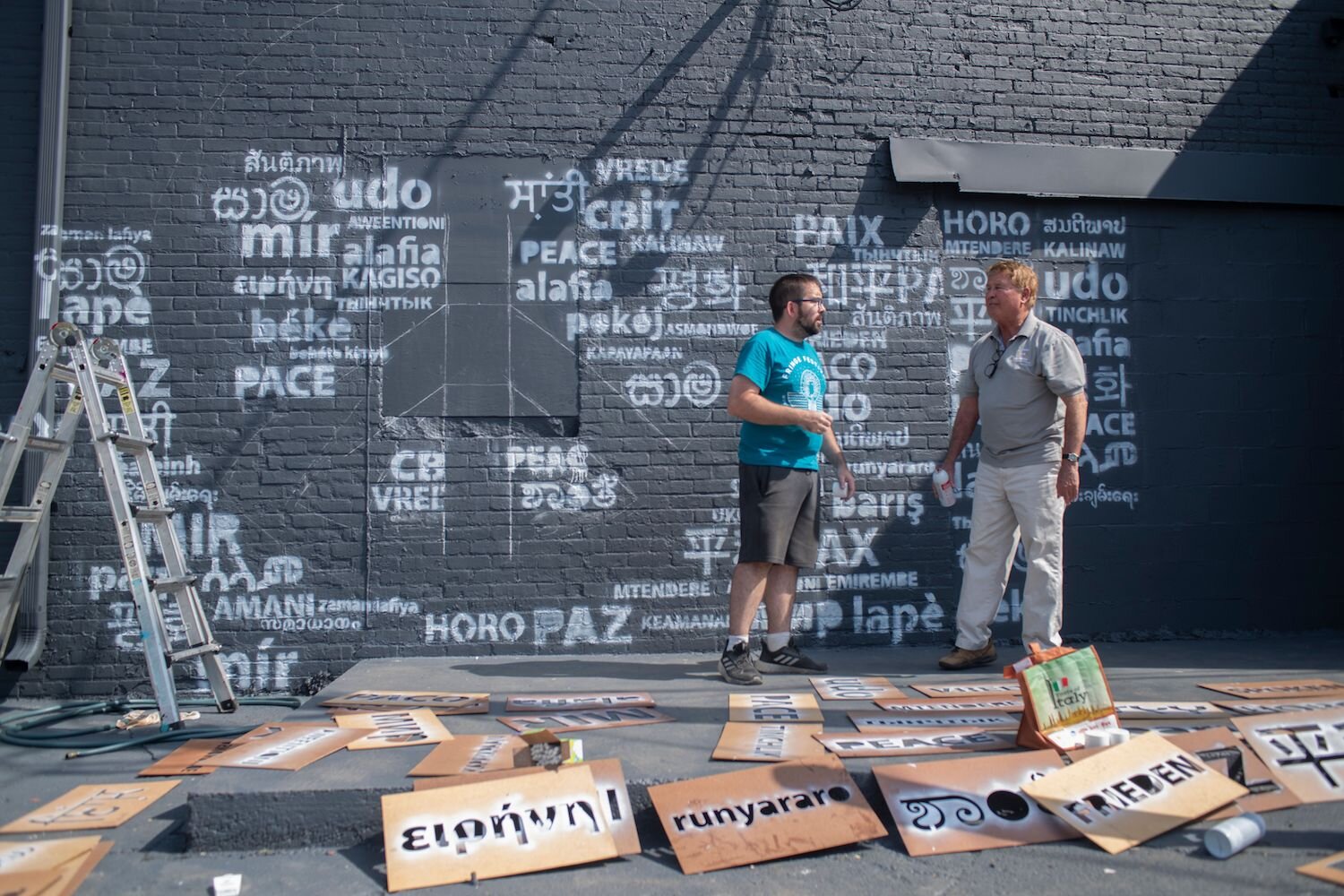 A peace sign emerges in the mural's negative space.