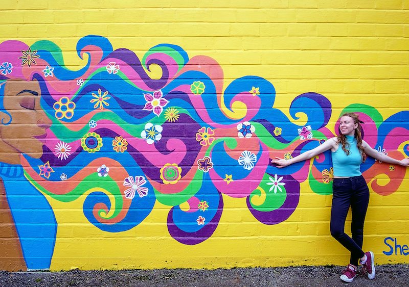 Art student Shelby Nower, 21, stands in front of her mural in downtown Decatur.