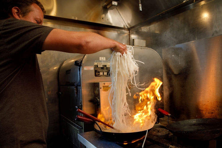 Chef Jesse Shoemaker cooks noodles to make pad thai.