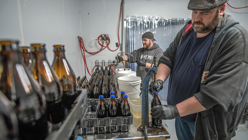 Head Brewer Joseph Hull, left, and Drew Wilks bottle and cap beer at HopLore.
