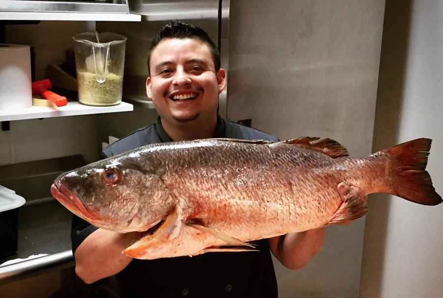 Chef Ricardo at Noa Noa proudly displays a fresh fish.