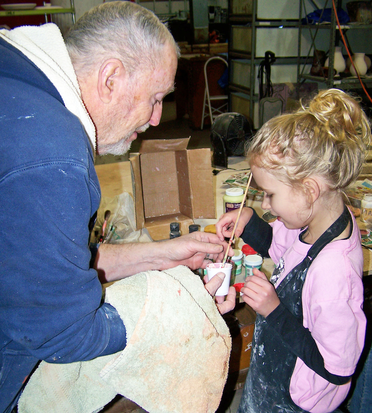 Ceramics teacher, Tom Sherbundy, helps 8-year-old Grace Walter mix glaze for a project at TekVenture.